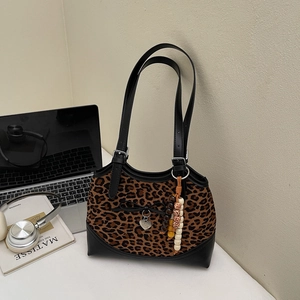 Detail of leopard print shoulder bag with bow, heart pendant and bohemian beads