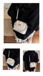 Detail of cream crossbody bag featuring checkerboard texture and silver chain strap