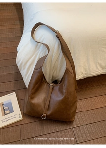 Detail of vintage brown wax leather tote bag with metallic ring and adjustable strap