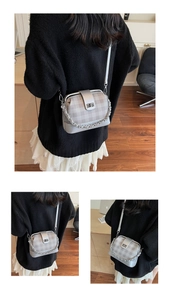 Detail of silver gray checkered crossbody bag with metal chain strap and twist lock closure