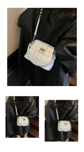Detail of blue checkerboard bag with silver chain handle and metal twist lock closure