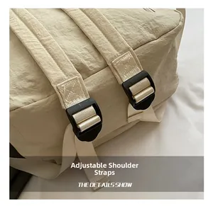 Détail du sac à dos en nylon beige montrant les bretelles réglables et boucles solides