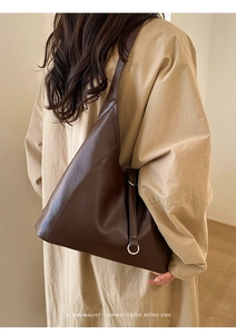 Macro detail of dark brown retro leather tote bag with stylish metal buckle on side
