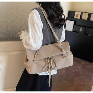 Detail of khaki suede tote with woven shoulder strap and decorative drawstring accents