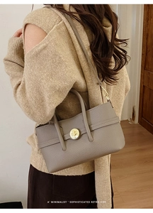 Detail of taupe retro handbag with lychee pattern leather and gold metal clasp
