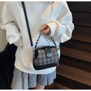 Detail of checkered doctor bag with silver metallic twist lock and dual chain straps