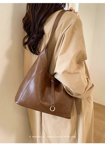 Detailed view of large dark brown leather tote bag with natural grain and metal rings