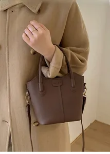 Detailansicht der dunkelbraunen Leder-Eimertasche mit Litschi-Muster und Goldbuckle