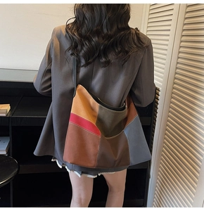 Detail of color block patchwork tote bag with suede texture and contrast white stitching