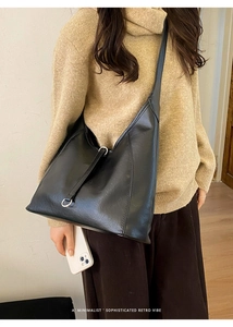 Detail of soft black faux leather tote with reinforced stitching and silver hardware ring