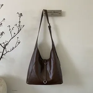Detail view of coffee tote bag with glossy faux leather and silver metal buckles