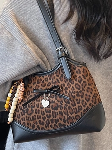 Chic leopard print shoulder bag with black bow and heart pendant detail for women
