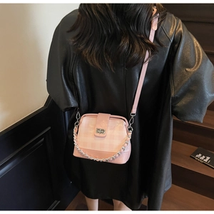 Close-up of pink checkered crossbody bag featuring silver twist lock and chain strap
