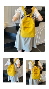 Vue détaillée du sac à dos en nylon jaune vif avec poche zippée et écusson logo rond
