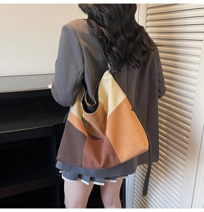 Minimalist color-block tote bag with adjustable strap worn by a model in a casual outfit