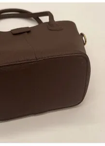 Detail des verstärkten Bodens der dunkelbraunen Lederbeuteltasche mit litchi-Maserung