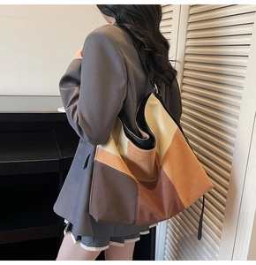 Detailed view of the large patchwork suede tote bag showing texture and earth tone colors