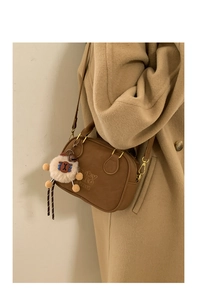 Brown vintage shoulder bag with fluffy sheep pendant and Spooky Studio embossed logo