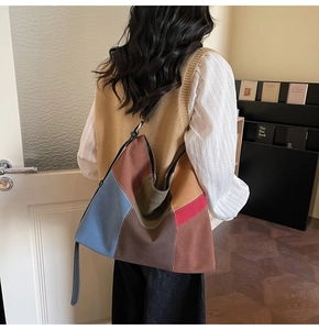 Detail view of multicolored patchwork suede tote bag with contrast stitching on the shoulder