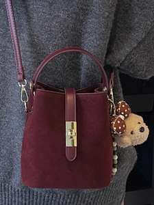 Retro burgundy suede bucket bag with top handle and bear charm for 2025 winter style