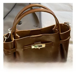 Detail of the golden twist lock hardware and premium brown leather on the bucket bag
