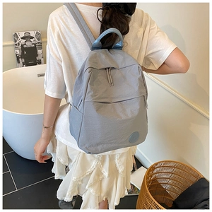 Détail d'un sac à dos décontracté bleu-gris avec poches multiples et fermetures éclair