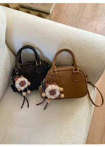 Detail of vintage bowling bags in black and brown leather with cute plush charms