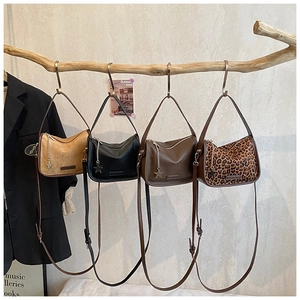 Detailed view of four retro crossbody bags hanging on a branch with star pendants