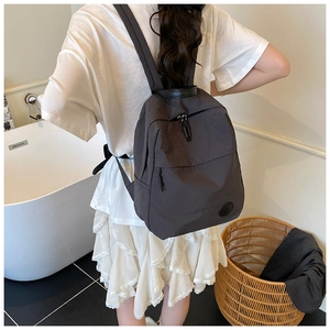 Vue arrière du modèle portant un grand sac à dos en nylon gris foncé stylé