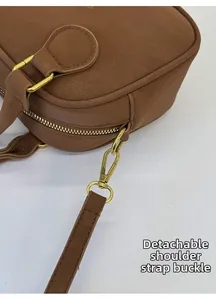 Close-up of brown litchi leather bag with detachable gold metal swivel hook and strap