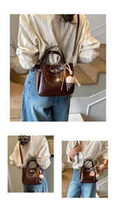 Detailed view of dark brown vintage bucket bag with elegant metallic clasp and charms