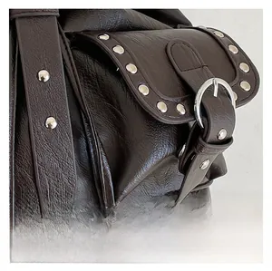 Détail du sac à dos rétro marron foncé avec texture cuir grainé et rivets argentés