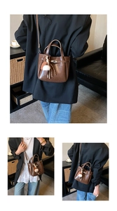Detail view of a vintage dark brown bucket bag with a cute plush ice cream charm accessory
