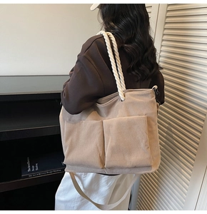 Detailed macro view of beige corduroy tote bag with cotton rope handles and large front pockets