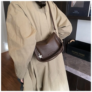 Close-up of dark brown lychee texture crossbody bag with star chain charm detail