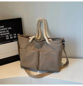 Detail view of khaki corduroy tote bag with rope handles and two front utility pockets