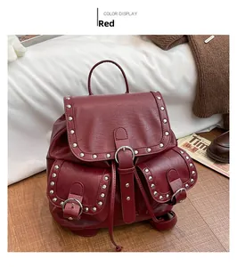 Gros plan d'un sac à dos vintage rouge foncé avec des clous argentés et boucles métal