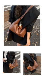 Detailed shot of brown woven leather tote bag with a cute plush doll charm