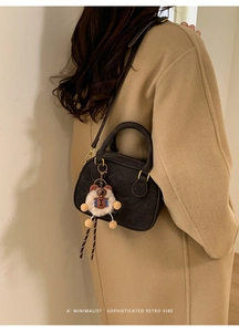 Detail showing retro brown crossbody bag with a cute plush bear pendant accessory