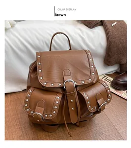 Détail d'un sac à dos vintage en cuir marron avec clous argentés et poches frontales