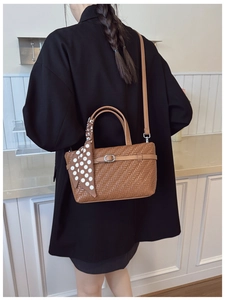 Brown woven handbag with polka dot scarf detail and crossbody strap on female model