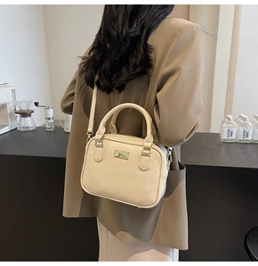 Minimalist beige crossbody square bag worn with brown blazer in a cafe setting