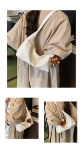 Close-up of white woven leather hobo bag with a brown plush monster charm accessory