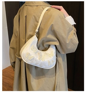 Close-up of white butterfly lace shoulder bag featuring 3D floral embroidery and hobo style
