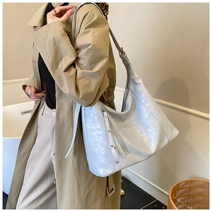 Détail du sac hobo bleu clair avec fini perlé et fermeture éclair sur l'épaule