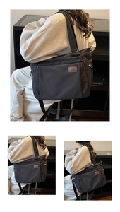 Détail d'un grand cabas noir avec écusson logo en cuir marron et poches zippées