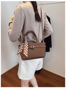 Brown woven texture handbag with polka dot silk scarf detail worn by a model
