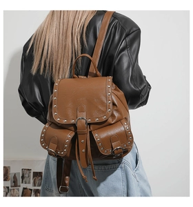 Gros plan d'un sac à dos vintage marron clouté avec boucles métalliques et cordon