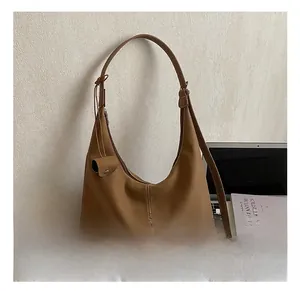 Détail d'un sac cabas marron minimaliste en similicuir avec un petit pendentif rond