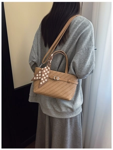 Close-up of woven crossbody bag with polka dot scarf detail and metal buckle accent